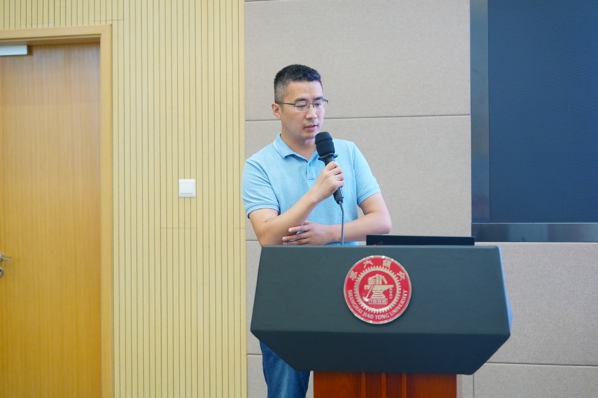 A person standing at a podium speaking into a microphone

Description automatically generated